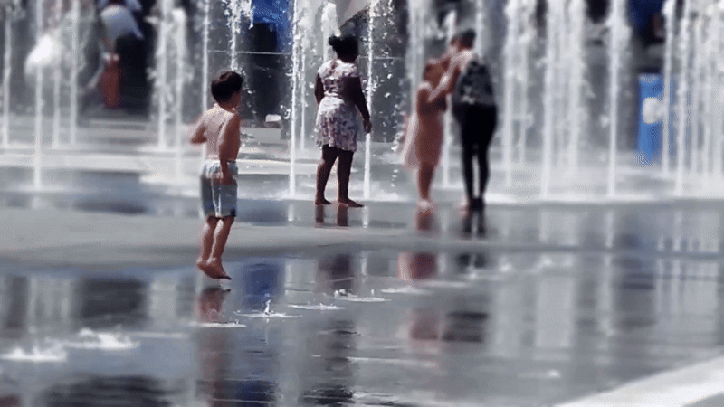 Crianças interagindo com uma fonte de piso